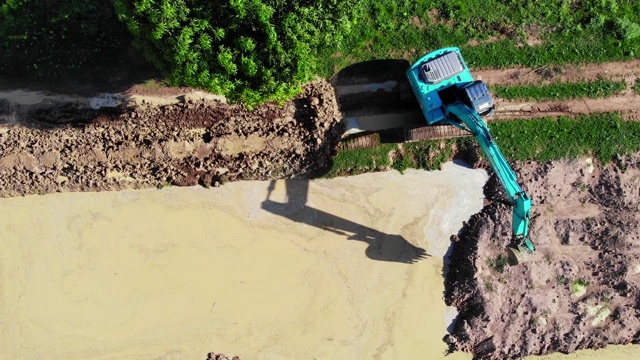 挖土机将泥土装进卡车，然后由卡车运送泥土出售。视频素材
