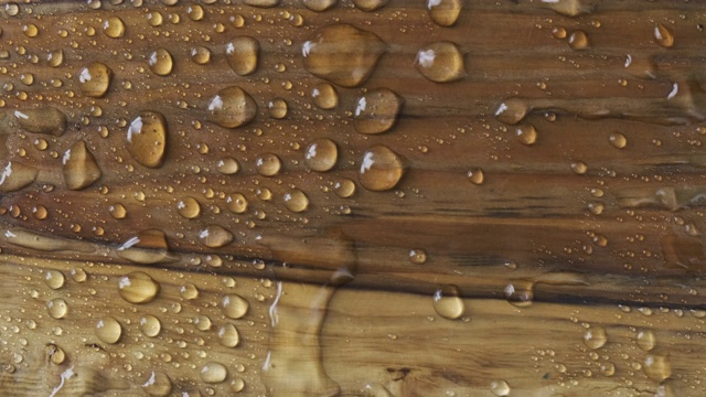 大风吹走了从棕色的木头表面上的雨滴。水与木的经典自然结合。视频素材