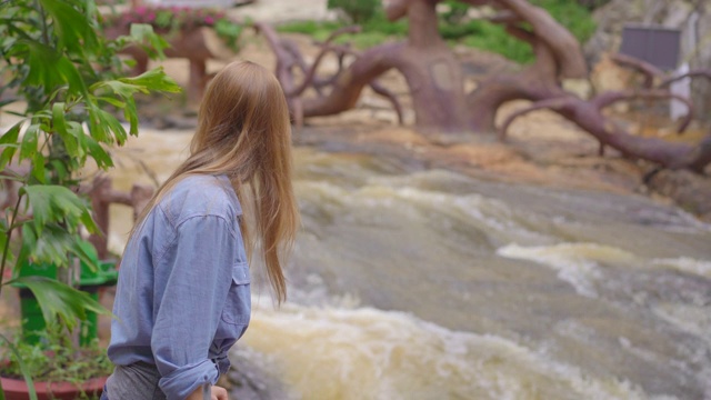 一个年轻的女人参观山上的瀑布。旅行到达拉特概念视频素材