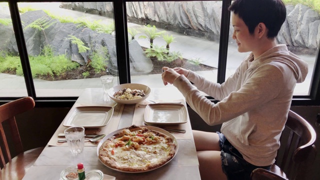 一名女博主用智能手机拍摄美食，在意大利餐厅拍视频，然后在网上发布社交媒体生活方式视频素材