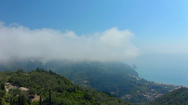 航拍科孚/科克拉山区村庄的云雾和阿吉欧斯·戈迪奥斯海滩视频素材