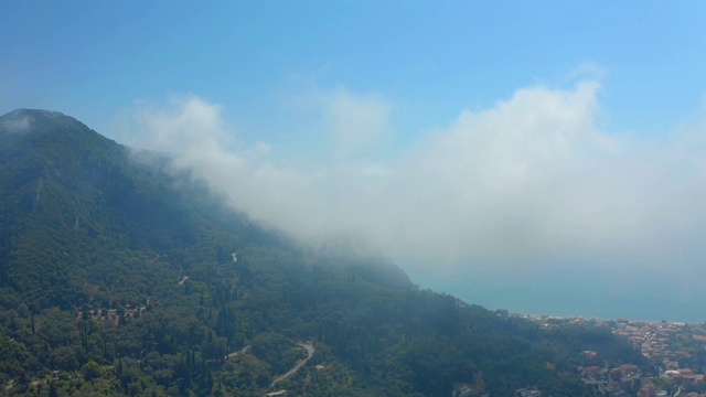 航拍科孚/科克拉山区村庄的云雾和阿吉欧斯·戈迪奥斯海滩视频素材