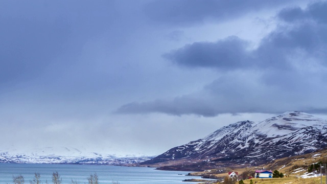 在冰岛阿库雷里的雪山峡湾，云滚动的时间流逝。视频下载