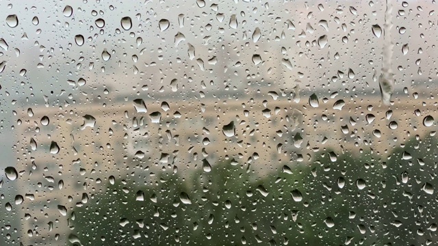 多雨的夏天。雨点打在背景模糊的窗户上。暴雨，气候变化概念。视频素材