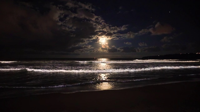 一轮满月在海浪上升起。戏剧性的日落海滩视频视频素材