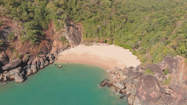 美丽的秘密海滩蝴蝶在果阿，印度。鸟瞰图的原始海滩与岩石湾和海浪冲击视频素材