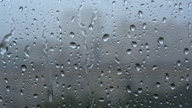 大雨。在刮风的雷雨中，雨滴从窗玻璃上滚下来。视频素材