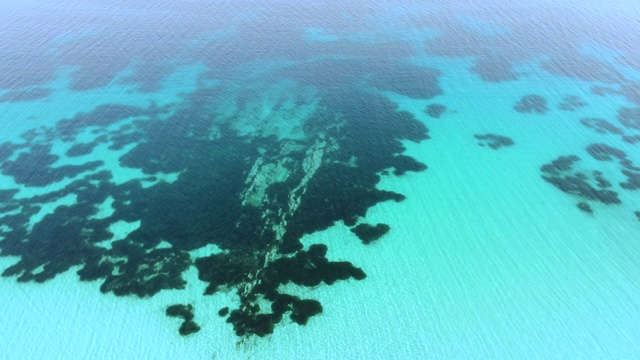 惊人的绿松石般透明的海水。在海面上飞行视频素材