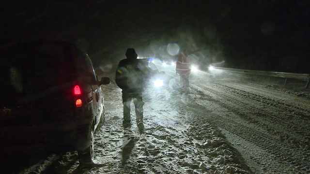 交通当局在积雪覆盖的道路上视频素材