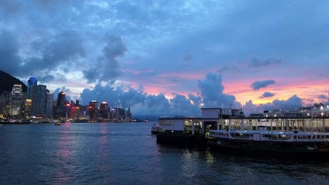 日落时分，繁忙的船只沿着维多利亚港航行，这是香港标志性城市天际线的一段时间视频素材