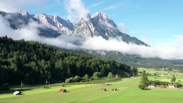 Zugspitze山是德国最高的山，位于巴伐利亚南部，与奥地利接壤。该影片从空中拍摄，前景是一片草地。视频素材