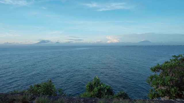 海洋景观与蓝色清澈的水，云和火山在地平线上视频素材