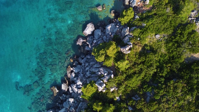 在岩石密布的海岸和宁静湛蓝的海面上缓慢飞行视频素材