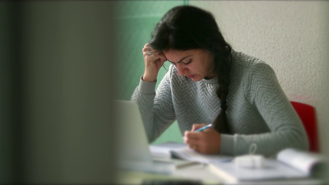 坦率的女人在家工作，随意真实的女学生在家做作业学习视频素材