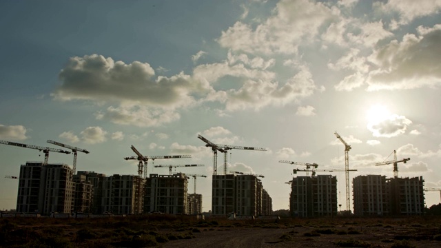 有许多起重机在建筑物上工作的大型建筑工地的工期视频素材