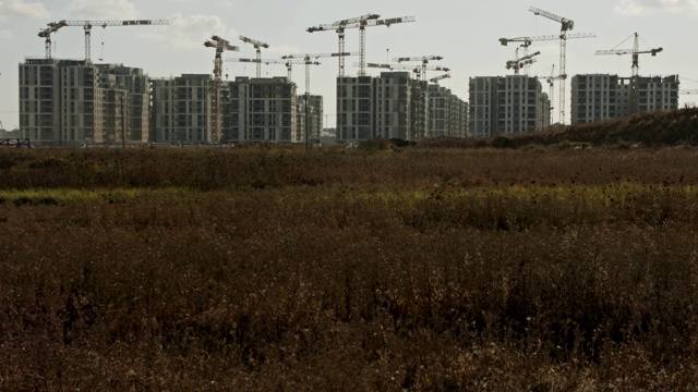 大型建筑工地，许多起重机在建筑物上工作视频素材