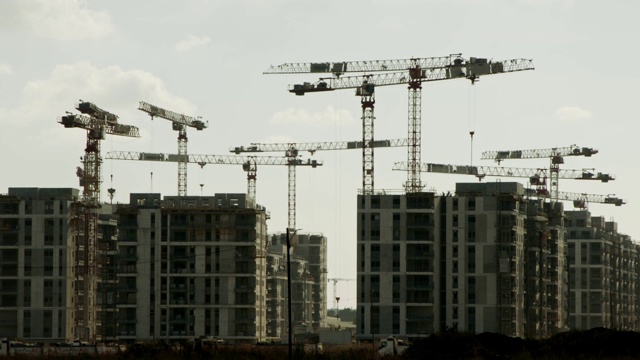 大型建筑工地，许多起重机在建筑物上工作视频素材