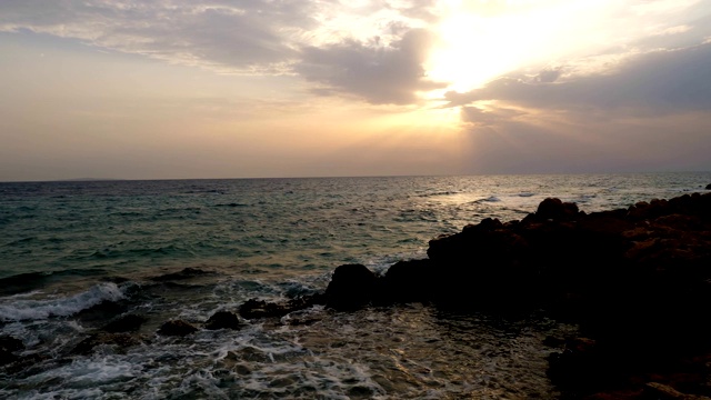 黎明，海面上的日出。美丽的海景，多岩石的海岸和海浪的泡沫视频素材