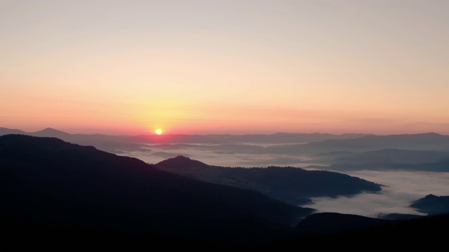 空中无人机视图。日出或日落在山上，飞过的大树在太阳V3视频素材