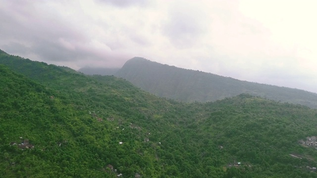 鸟瞰图的乡村村庄在山上充满了郁郁葱葱的热带植物视频素材