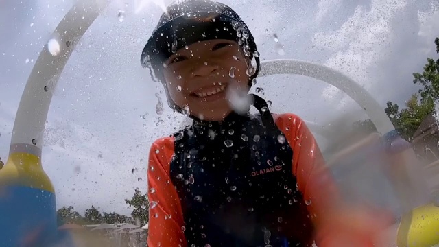 小男孩正在水上乐园的水隧道里奔跑。视频素材