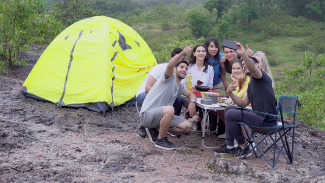 快乐的一群朋友带着照片背包在夏天旅行冒险，旅游和拍照与智能手机在露营，自拍社交和旅行与手机在假期。视频素材