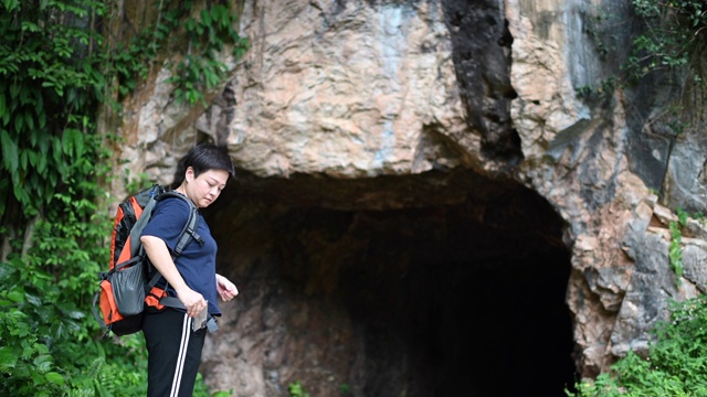 后视图一个亚洲华人中年女性旅行徒步探索怡保霹雳马来西亚洞穴森林背包视频素材