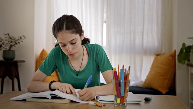 十几岁的女孩坐在家里准备学校的家庭作业视频素材