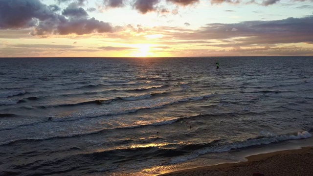 大海在美丽的日落风筝滑板风筝在背景。空中无人机拍摄。海上日出。视频素材