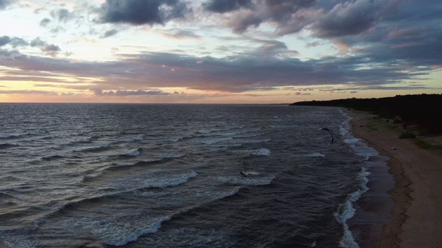 大海在美丽的日落风筝滑板风筝在背景。空中无人机拍摄。海上日出。视频素材