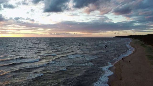 大海在美丽的日落风筝滑板风筝在背景。空中无人机拍摄。海上日出。视频素材