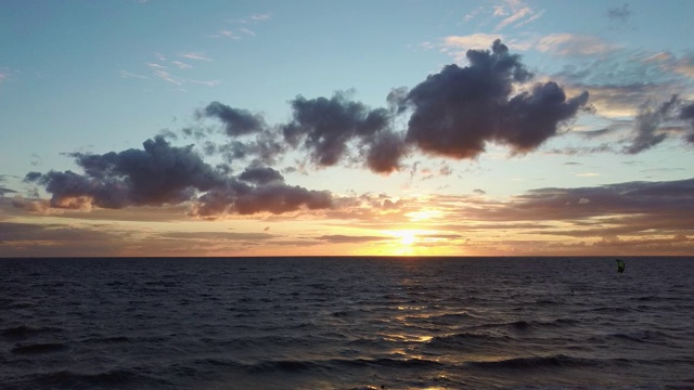 大海在美丽的日落风筝滑板风筝在背景。空中无人机拍摄。海上日出。视频素材