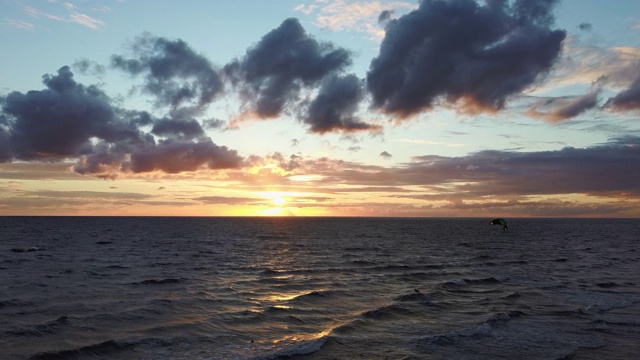 大海在美丽的日落风筝滑板风筝在背景。空中无人机拍摄。海上日出。视频素材