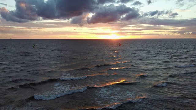 大海在美丽的日落风筝滑板风筝在背景。空中无人机拍摄。海上日出。视频素材