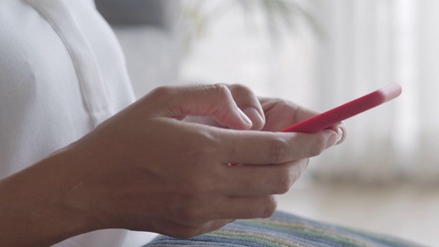 侧视图。女人的手在家里使用智能手机。特写的年轻女商人的手视频素材