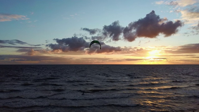 大海在美丽的日落风筝滑板风筝在背景。空中无人机拍摄。海上日出。视频素材