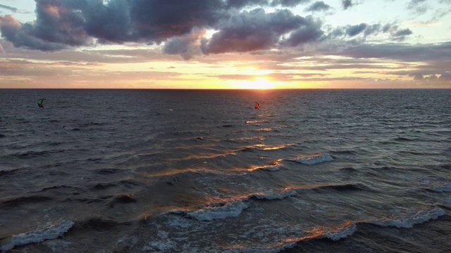 大海在美丽的日落风筝滑板风筝在背景。空中无人机拍摄。海上日出。视频素材