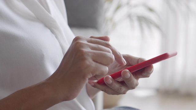 侧视图。女人的手在家里使用智能手机。特写的年轻女商人的手视频素材