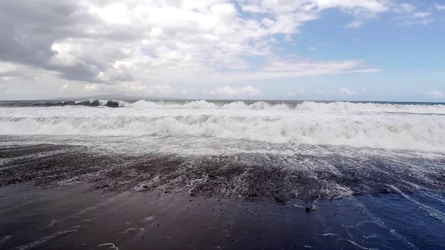 巨大的海浪拍打着黑色火山海滩的海岸。慢动作的观点。视频素材