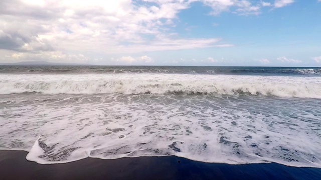 巨大的海浪拍打着黑色火山海滩的海岸。缓慢的运动。视频素材