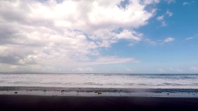 平静的小海浪拍打着黑色的火山海滩。缓慢的运动。视频素材