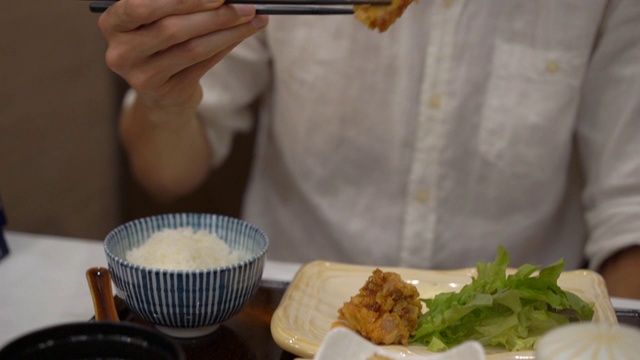 一个年轻人在日韩咖啡馆吃亚洲食物的慢动作镜头视频素材