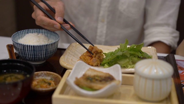 一个年轻人在日韩咖啡馆吃亚洲食物的慢动作镜头视频素材