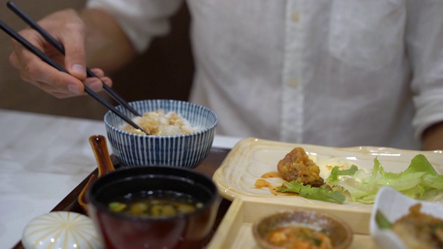 一个年轻人在日韩咖啡馆吃亚洲食物的慢动作镜头视频素材