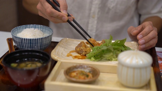 一个年轻人在日韩咖啡馆吃亚洲食物的慢动作镜头视频素材