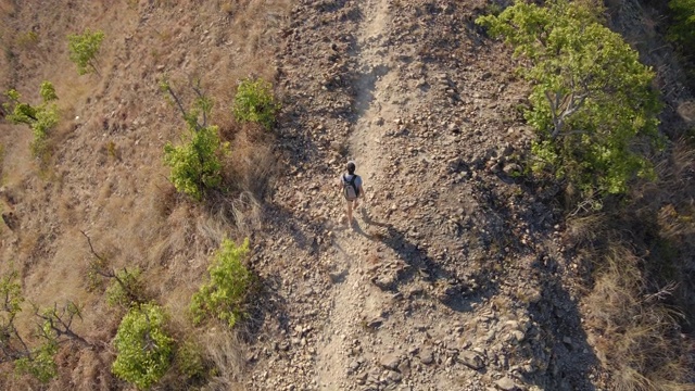 一个年轻人在山里徒步旅行的航拍照片视频素材