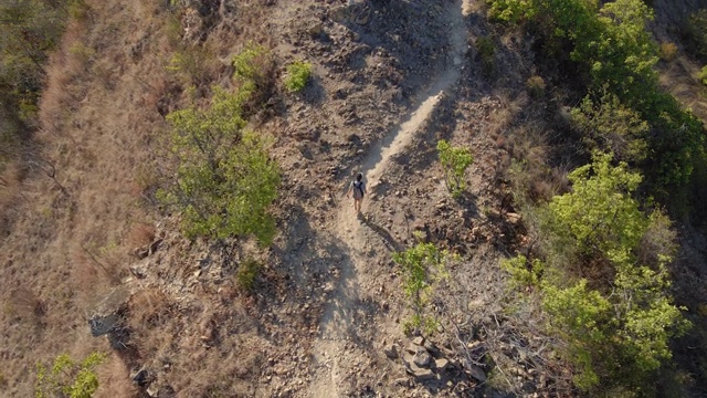 一个年轻人在山里徒步旅行的航拍照片视频素材