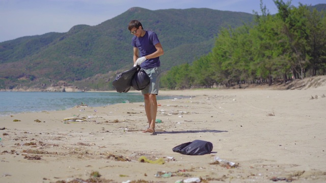 戴手套的人在海滩上收集塑料垃圾。沙滩上的垃圾问题是由人为污染造成的。环保运动，清洁环境。生态志愿服务概念视频素材