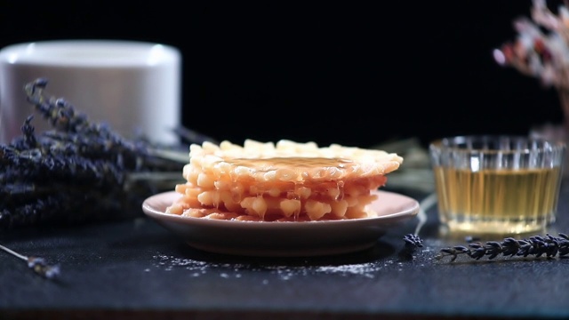 在深色背景上滴着蜂蜜的华夫饼，特写视频素材