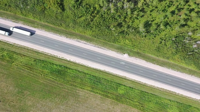 空中旋转的一个快速卡车在乡村的道路上绿色的草视频下载